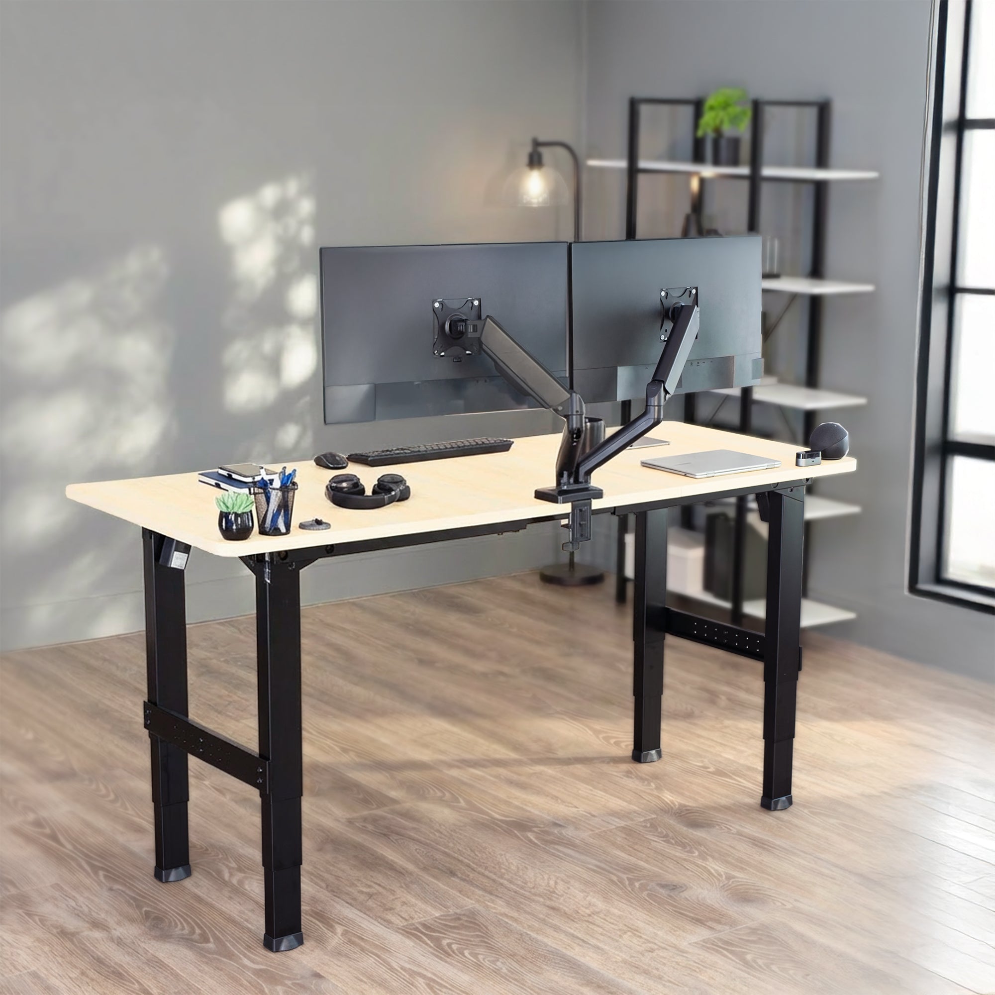 Black Premium Electric Dual-Motor Height Adjustable 4-Leg Desk Frame in an office with a dual monitor setup