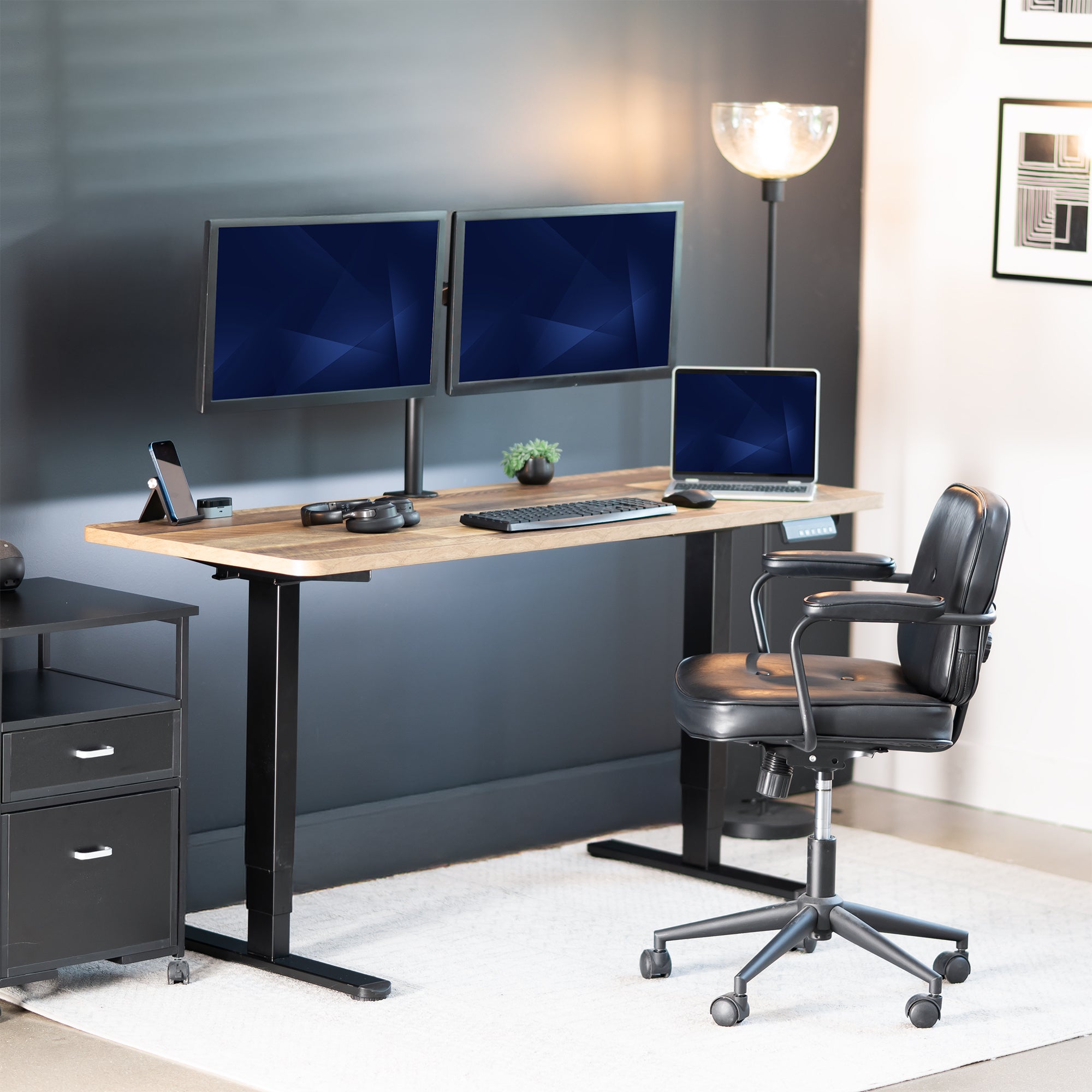 Modern office setup with a standing desk, dual monitors, and a chair.