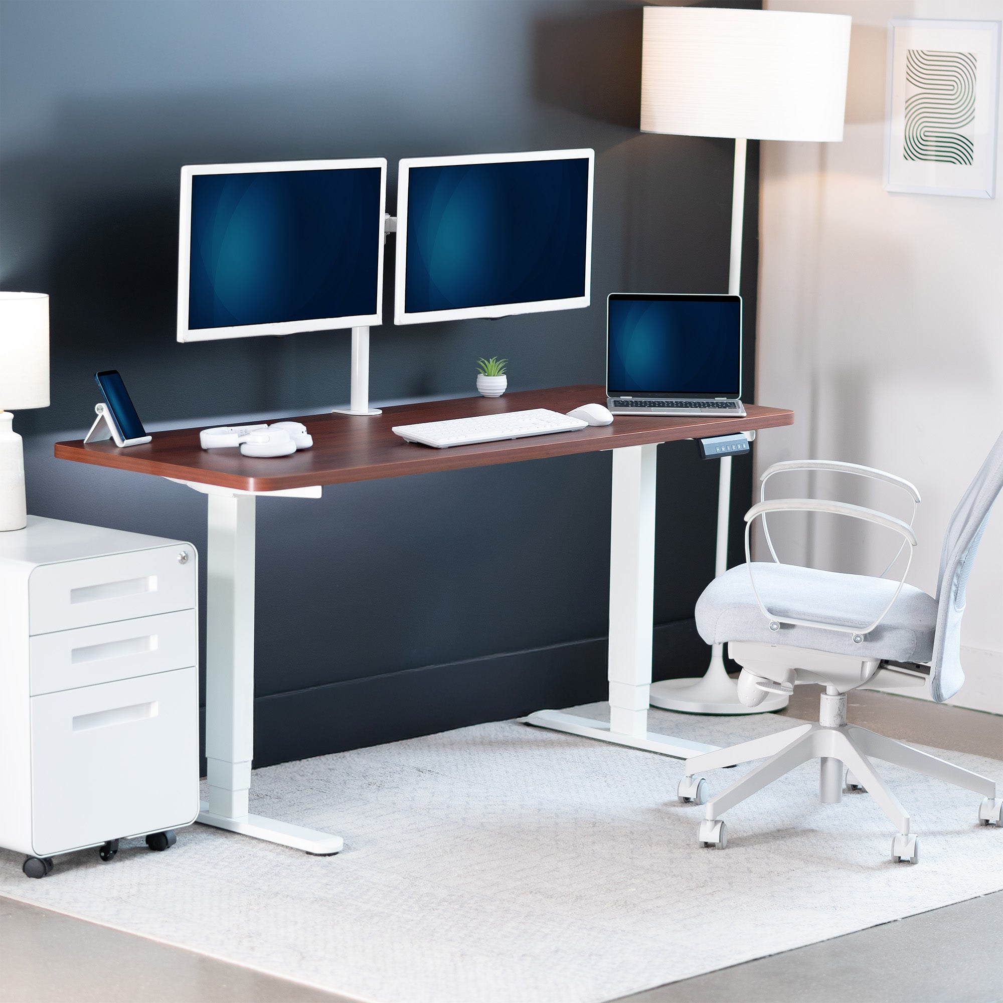 Modern office setup with a standing desk, computer monitors, and chair.
