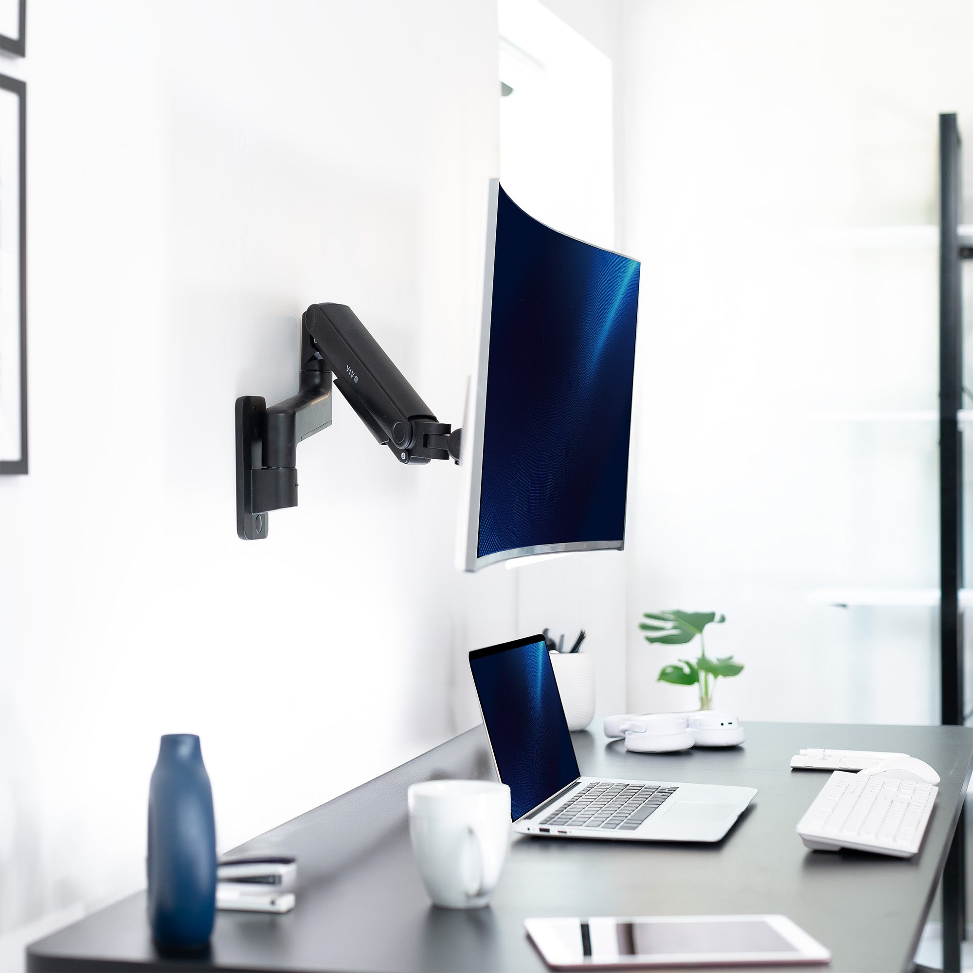 Mechanical Arm Single Ultrawide Monitor Wall Mount floating above desk.