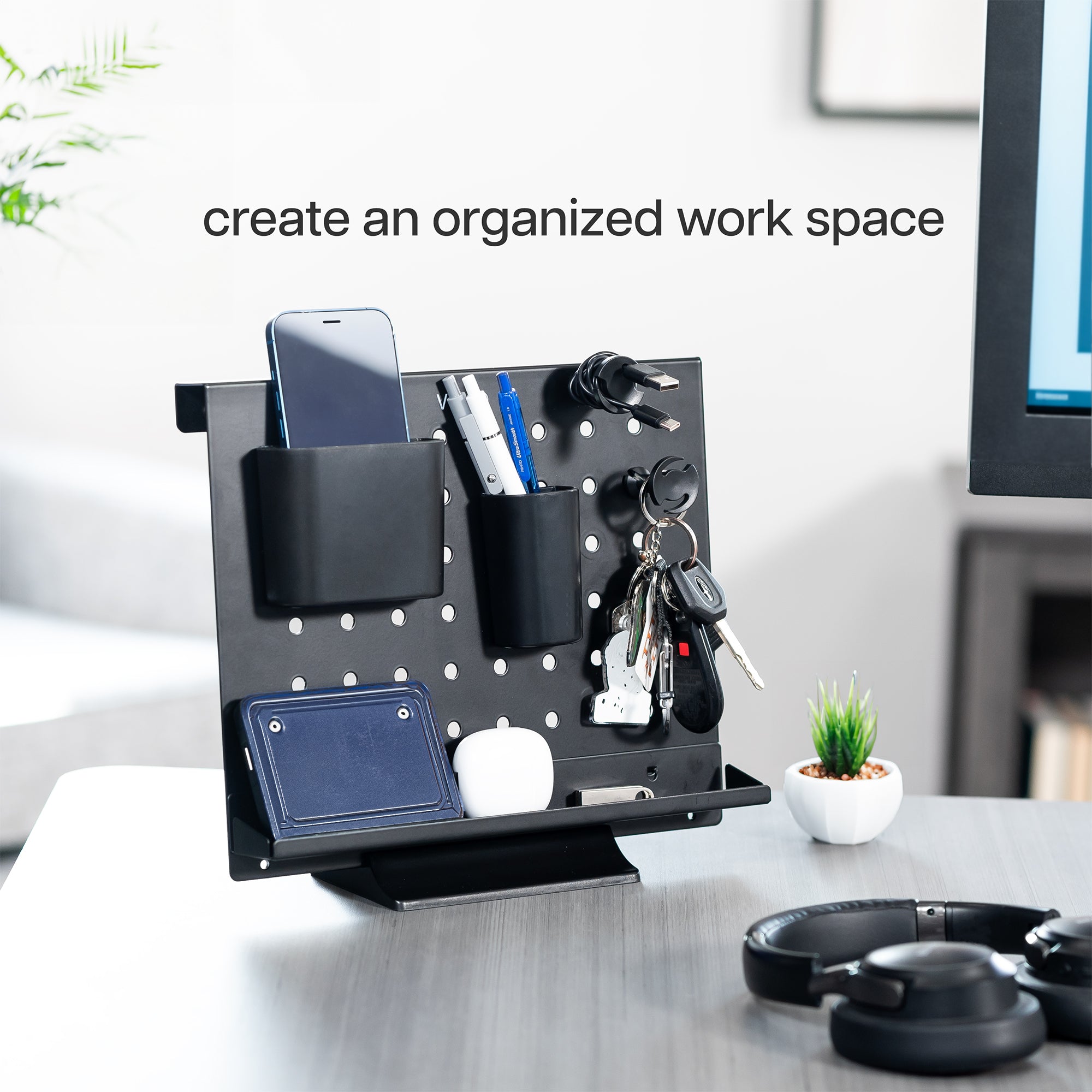 A black pegboard desk organizer with various slots and holders for office supplies and a mobile phone.