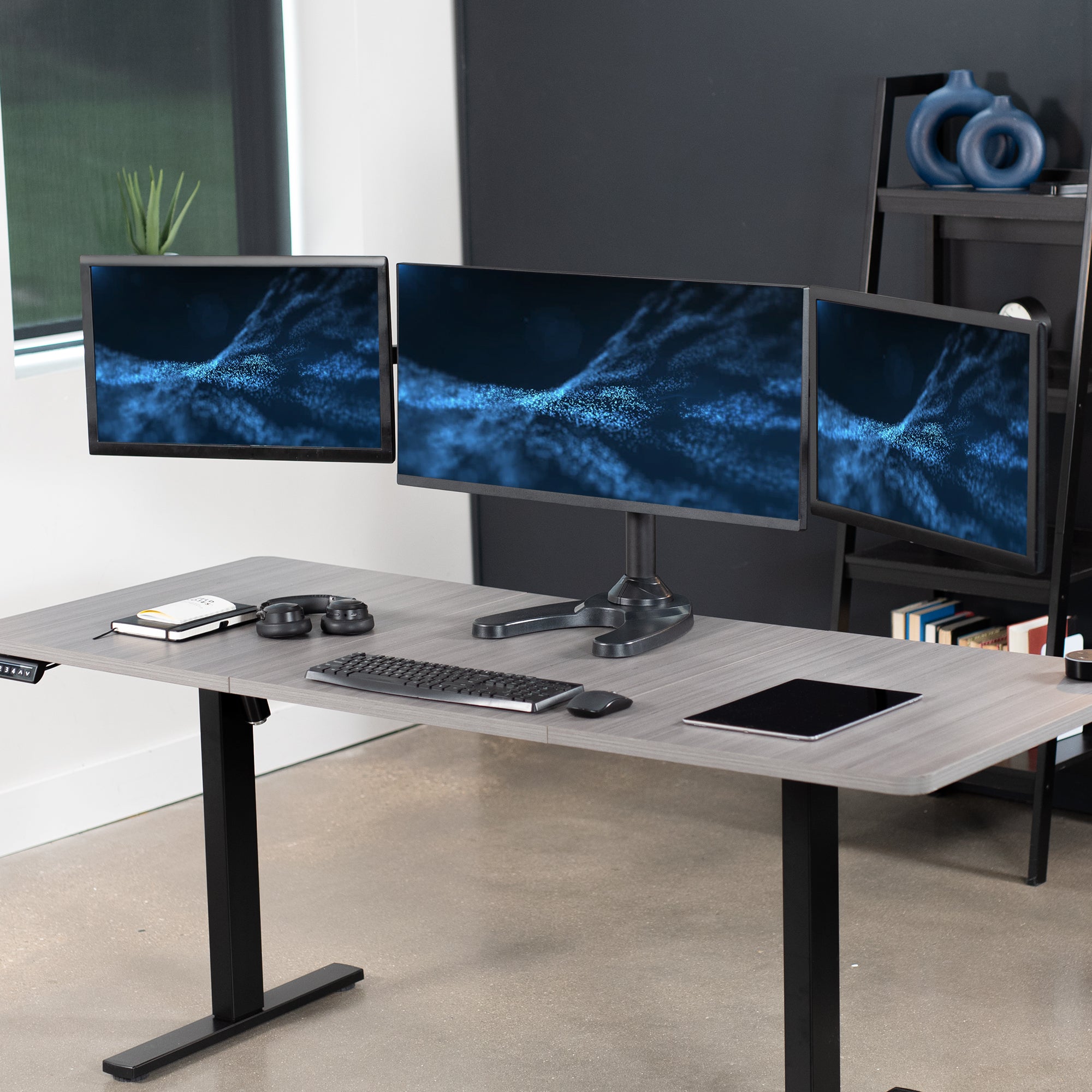 Triple Monitor Desk Stand on desk in office setting.
