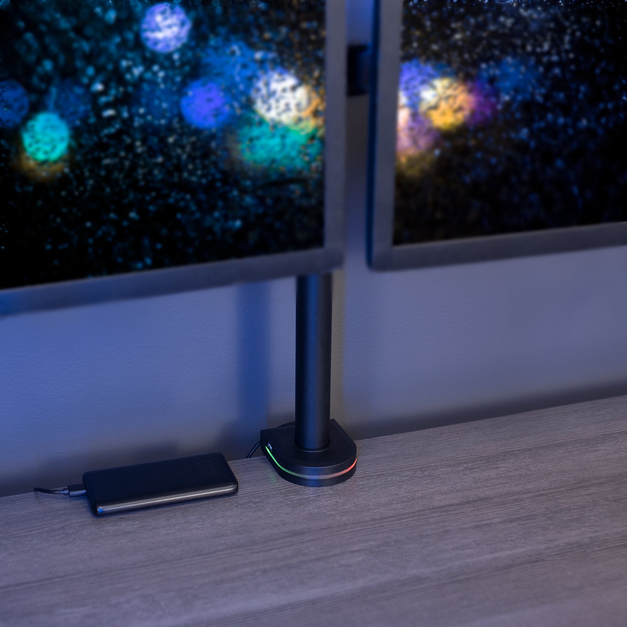 Dual color-changing monitor mount base for modern work or gaming space setups.