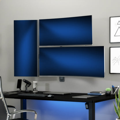 Modern office setup with three monitors on a wall above a desk.