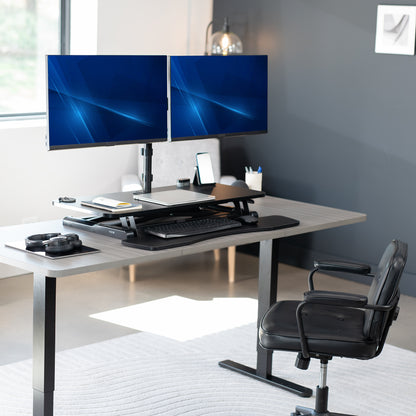 36 inch height adjustable desk riser with articulating mechanical dual monitor mount.