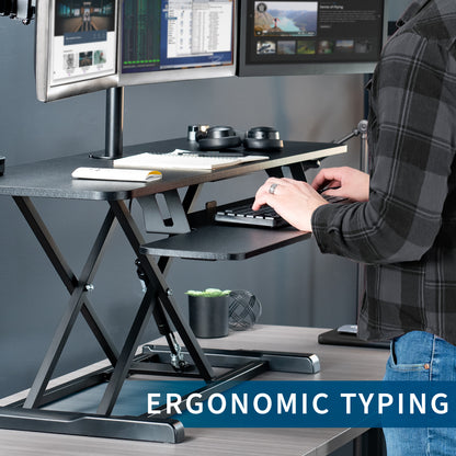 Spacious height adjustable desk riser with articulating triple monitor mount.