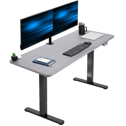 Gray adjustable desk with two monitors, keyboard, and office supplies on a white background