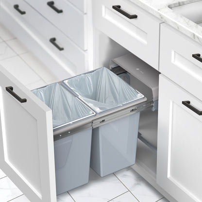 An under-counter dual trash can system with silver containers and a beige lid. 