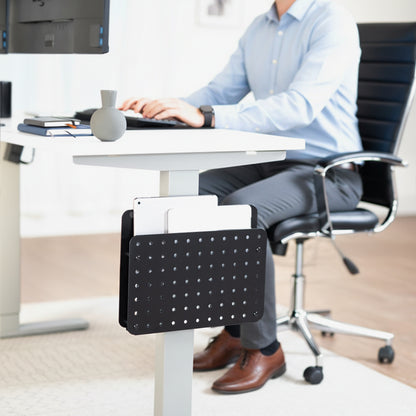 Person sitting at a desk with a black office chair and a Steel Clamp-on Desk Leg Laptop Mount Holder attached to the desk.