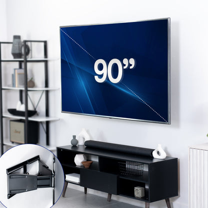 Large flat-screen TV displaying '90"' in mounted on a TV wall mount in a living room setting with a black entertainment console.