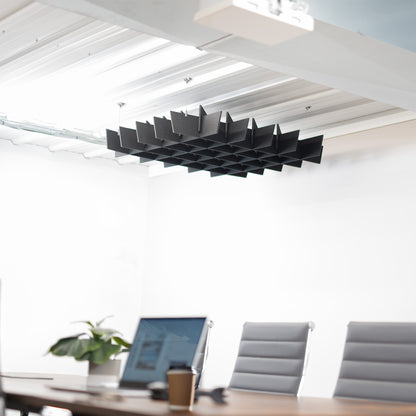 A black acoustic dual-layer ceiling waffle panel with a geometric pattern, mounted on a ceiling in a conference room. 