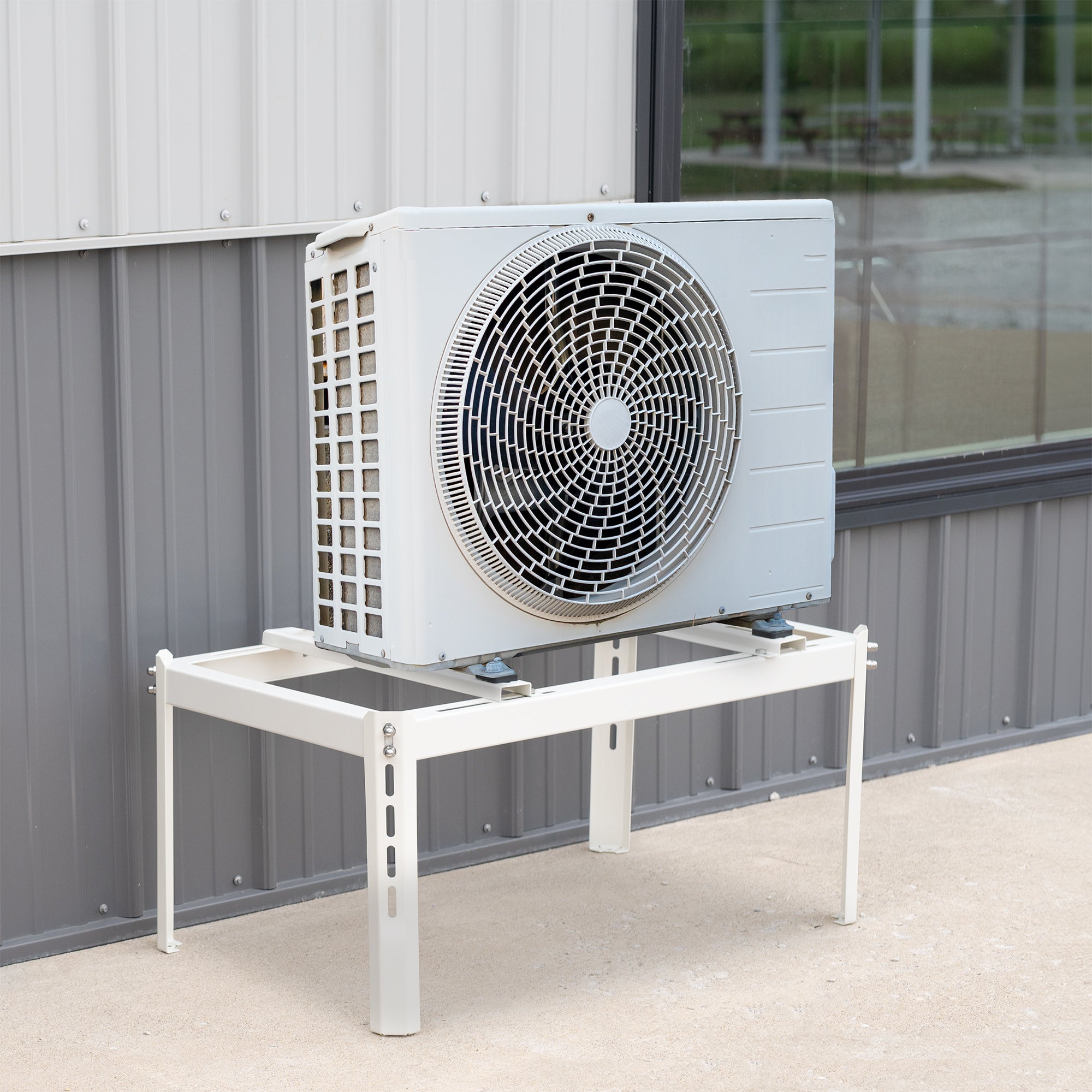 Mini Split Air Conditioner Ground Stand with air conditioner on it against building.