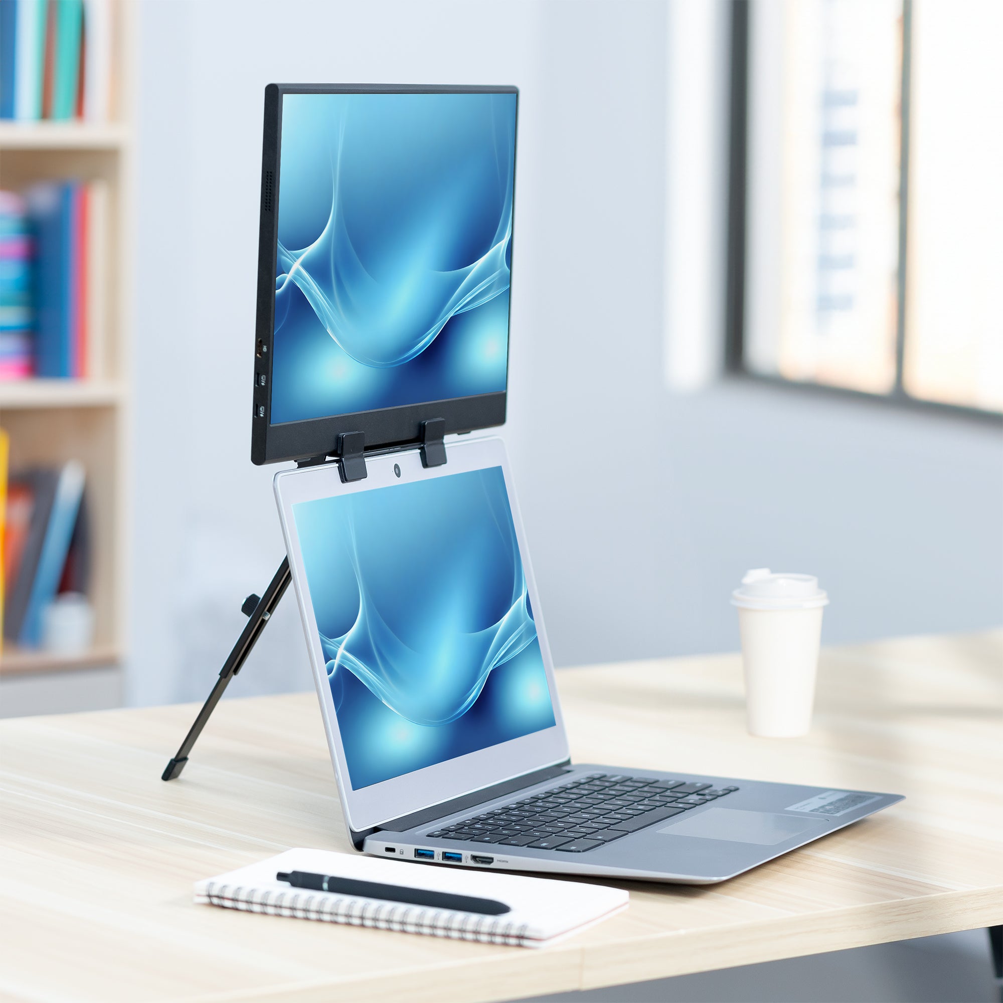 A black portable monitor laptop extension holder with a foldable design in an office. 