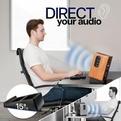 Person sitting at a desk with a speaker playing audio on the Angled Desktop Speaker Stands (2 Pack) showing the 15 degree tilt