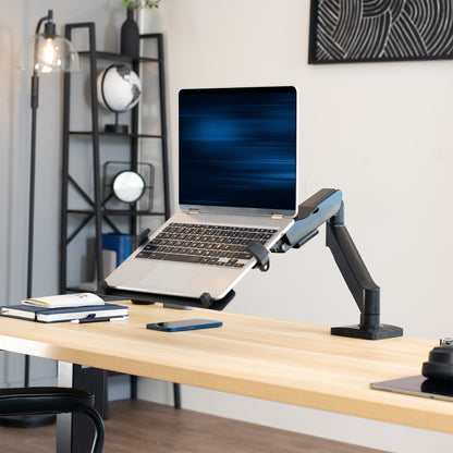 Laptop on a adjustable desk mount on a wooden desk with a modern office background