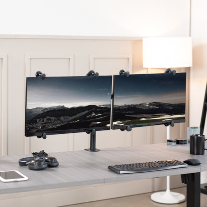 Dual Monitor Desk Mount with VESA Adapter Bracket on desk in office setting.