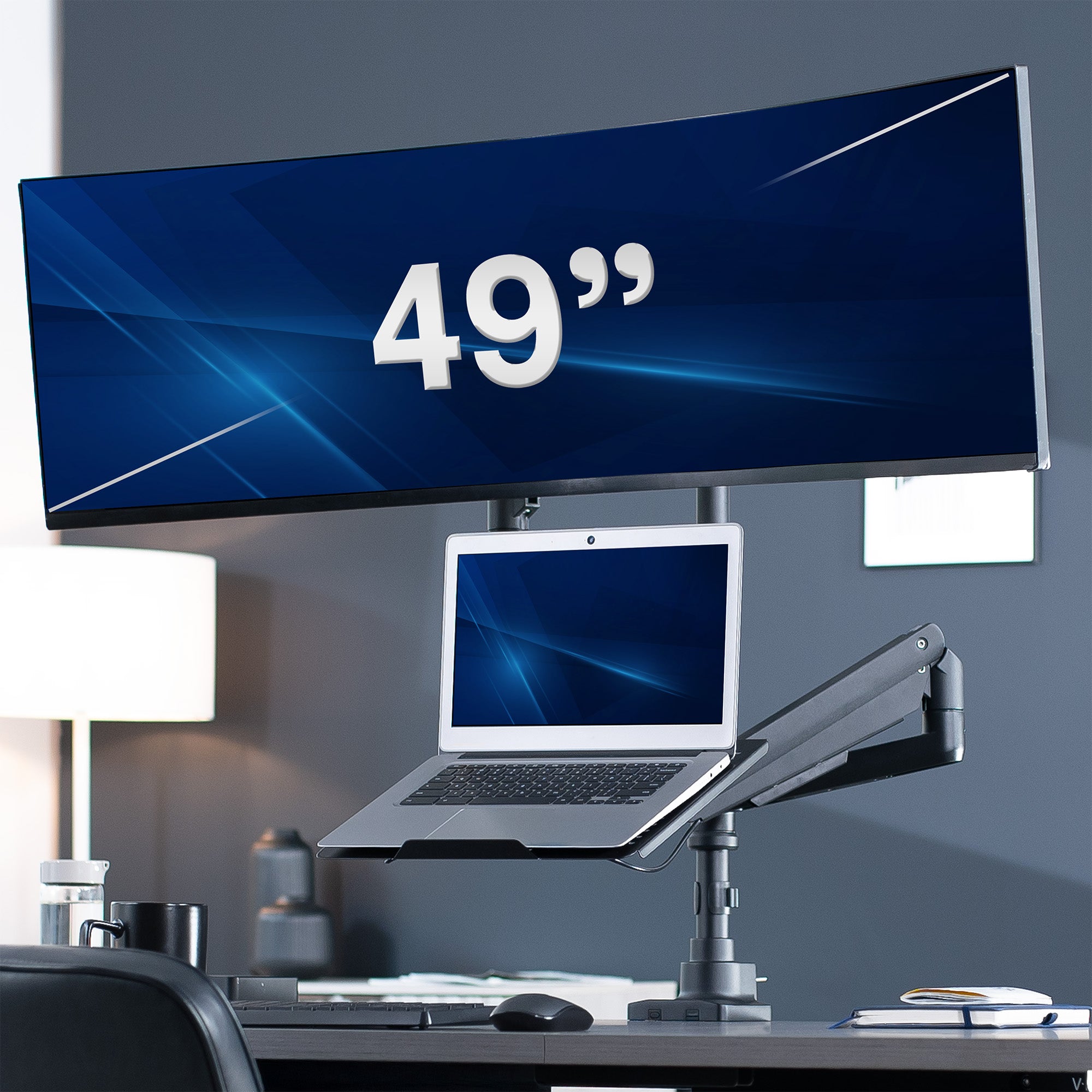 Laptop on a stand with an ultrawide monitor in a home office setting.