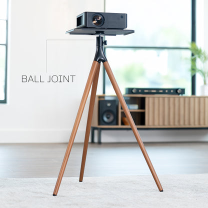 Projector on a wooden tripod in a room with furniture and decor.