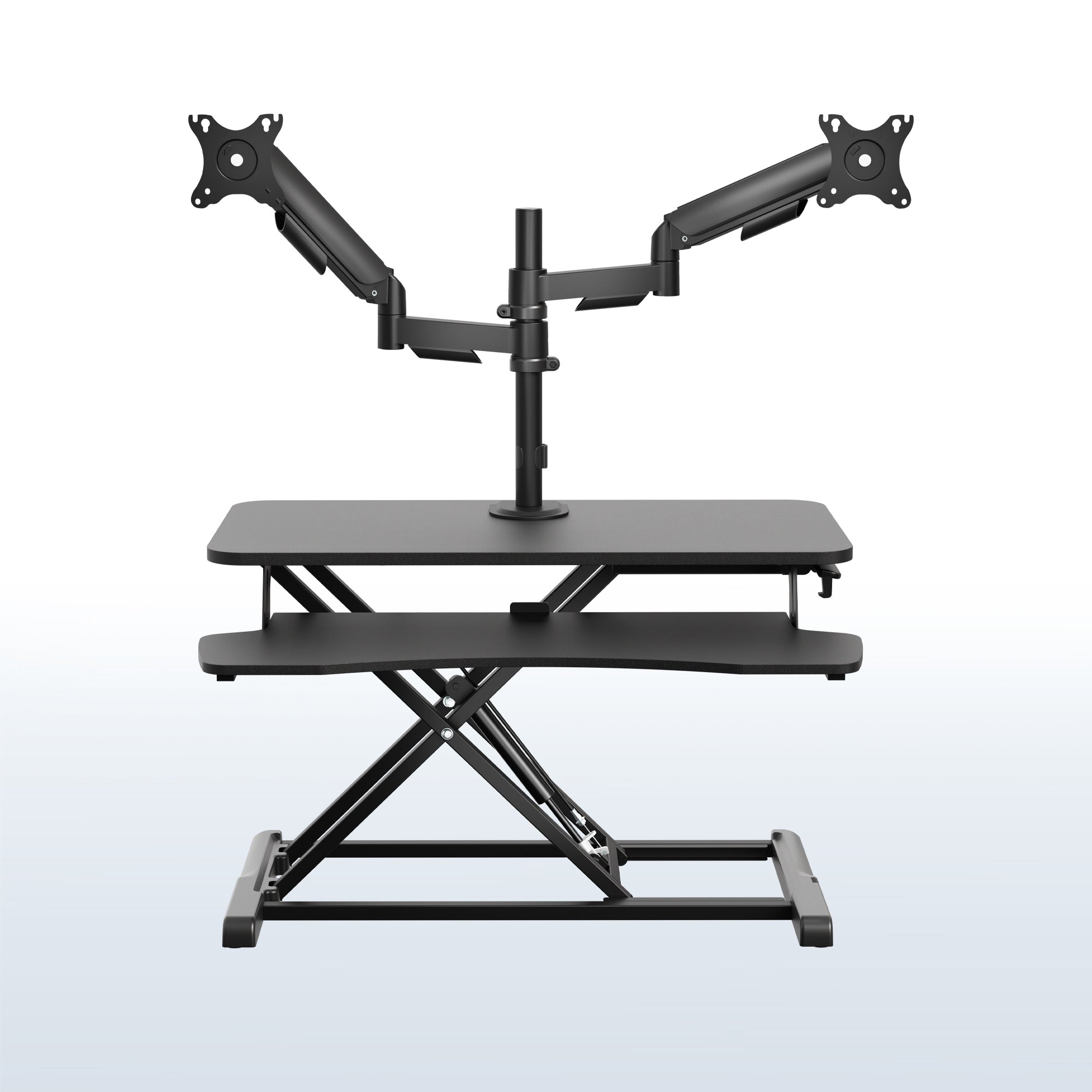 Height adjustable desk riser with articulating mechanical dual monitor mount.