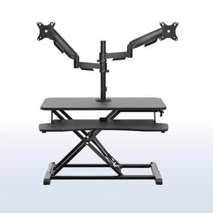 Height adjustable desk riser with articulating mechanical dual monitor mount.