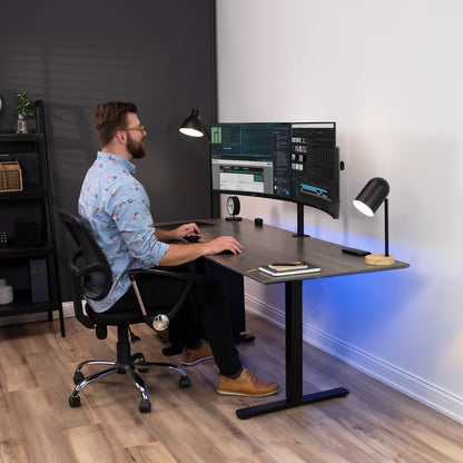 Male model sitting at desk with dual monitor mount.