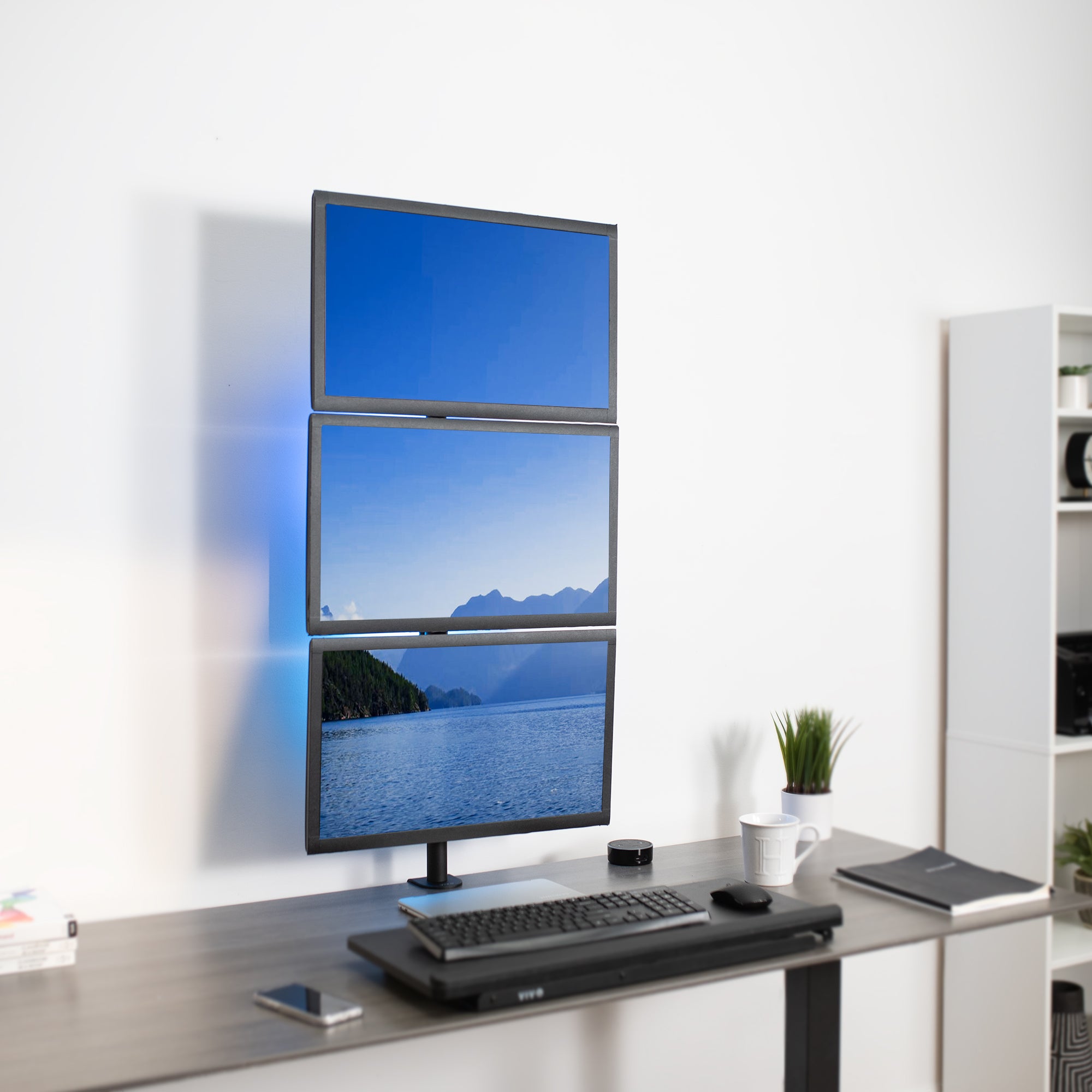 Triple Vertical Monitor Desk Mount on desk in office setting. 